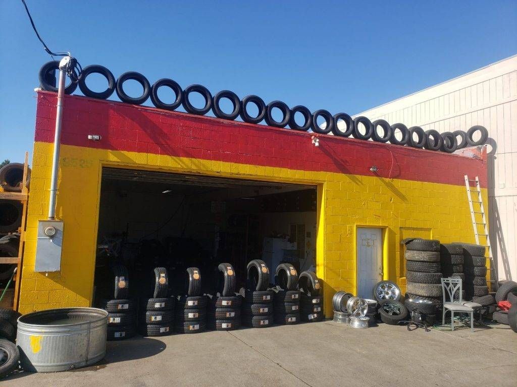 A yellow and red building with tires hanging from the roof