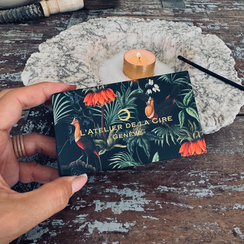 Main tenant une boîte à imprimé floral foncé avec le texte