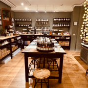 Intérieur d'un magasin avec des étagères de produits et une table centrale avec des sièges.