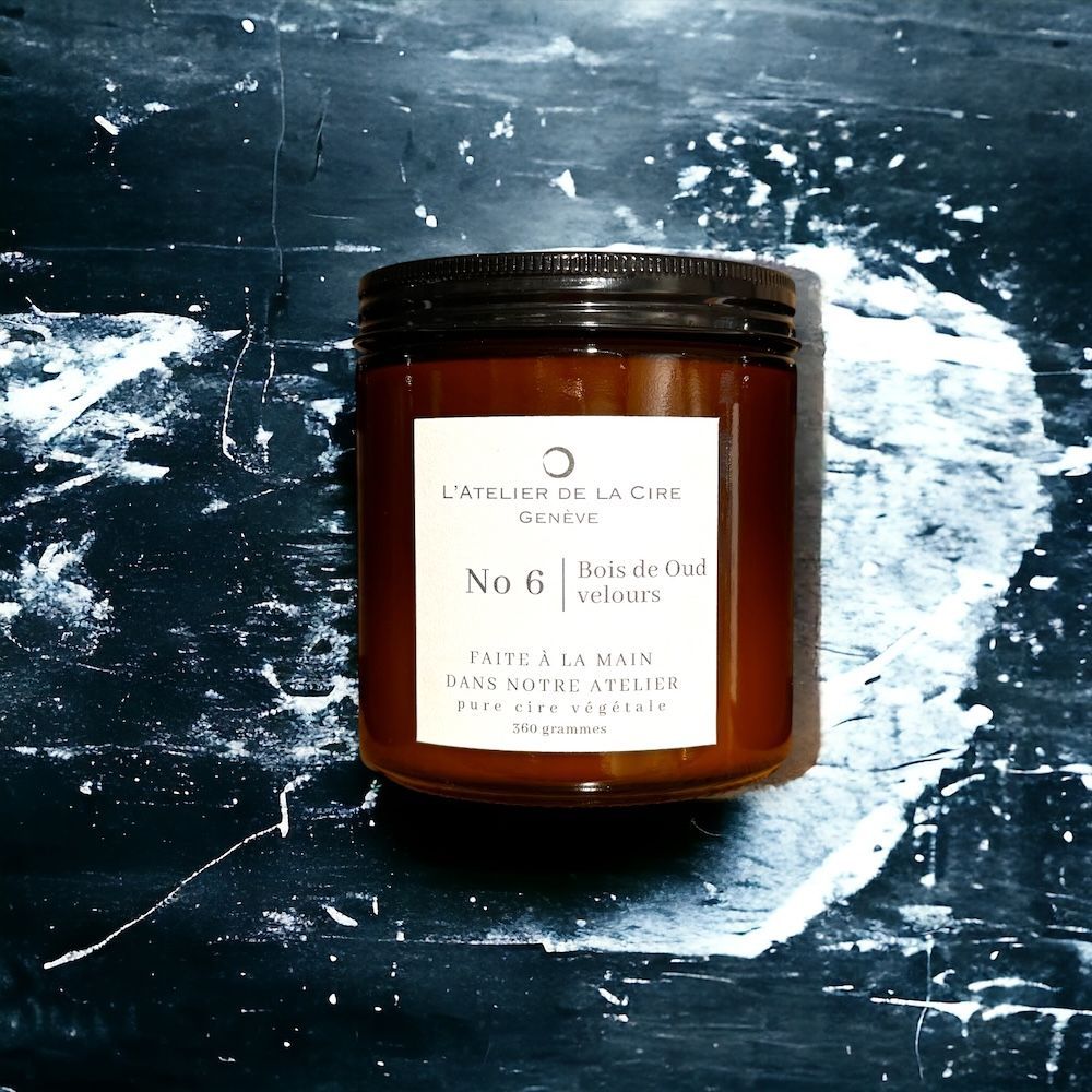 Bougie brune dans un pot en verre avec un couvercle noir, l'étiquette indique « Bois de Cèdre ».