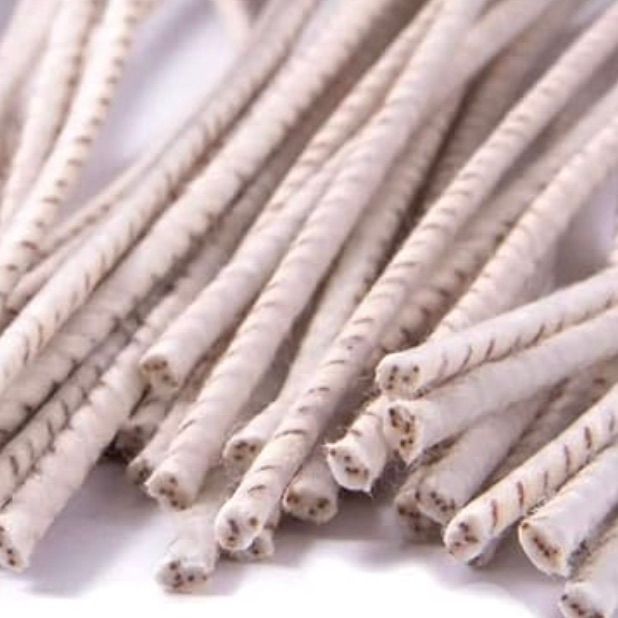 Paquet de pétards cylindriques blanc cassé avec des stries brun foncé sur toute leur longueur et une ouverture à quatre trous à chaque extrémité.