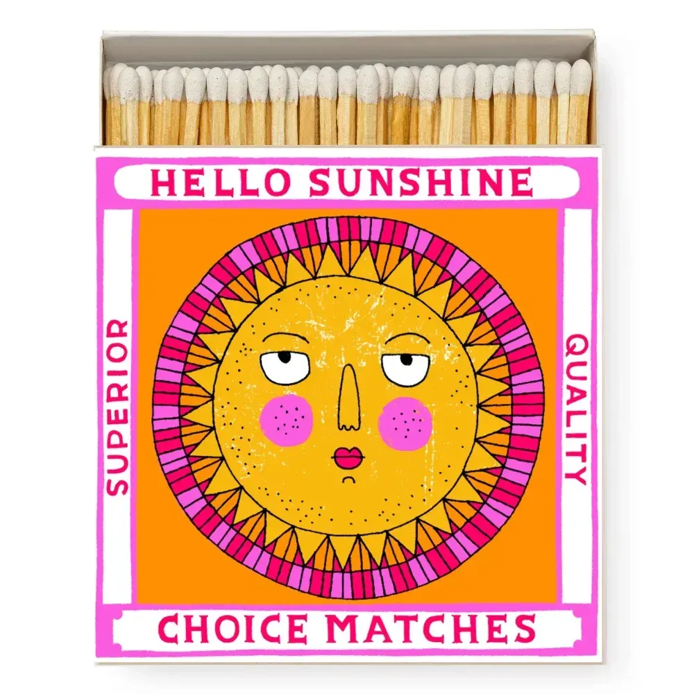 Boîte d'allumettes avec un soleil au visage grincheux sur le devant, le texte dit « Bonjour Sunshine Choice Matches ».