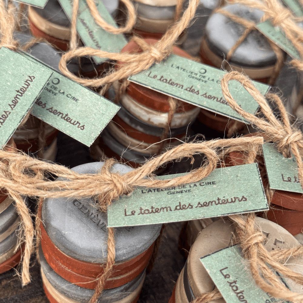 Petites piles de disques d'argile colorés attachés avec de la ficelle, chacun avec une étiquette, sur une planche de bois.