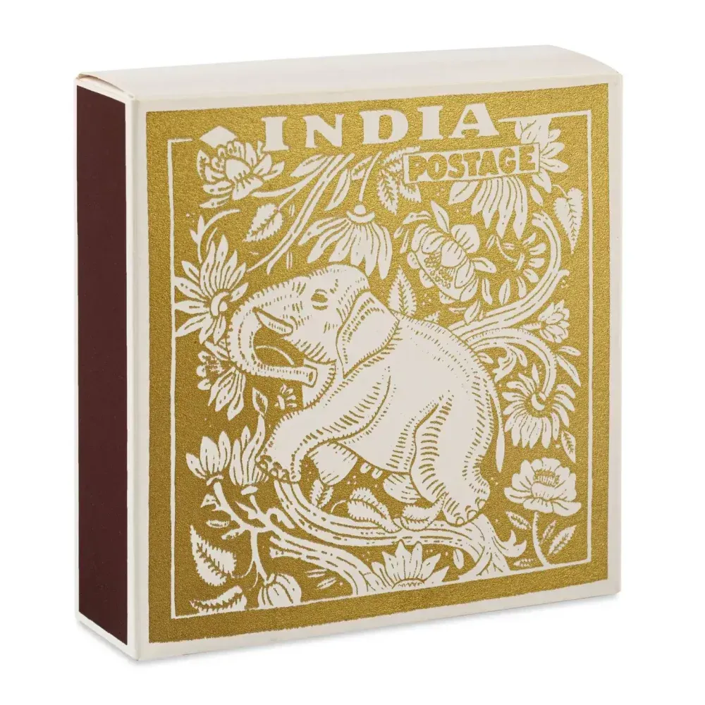 Boîte d'allumettes avec motif floral et éléphant doré, étiquetée « INDIA POSTAGE ».