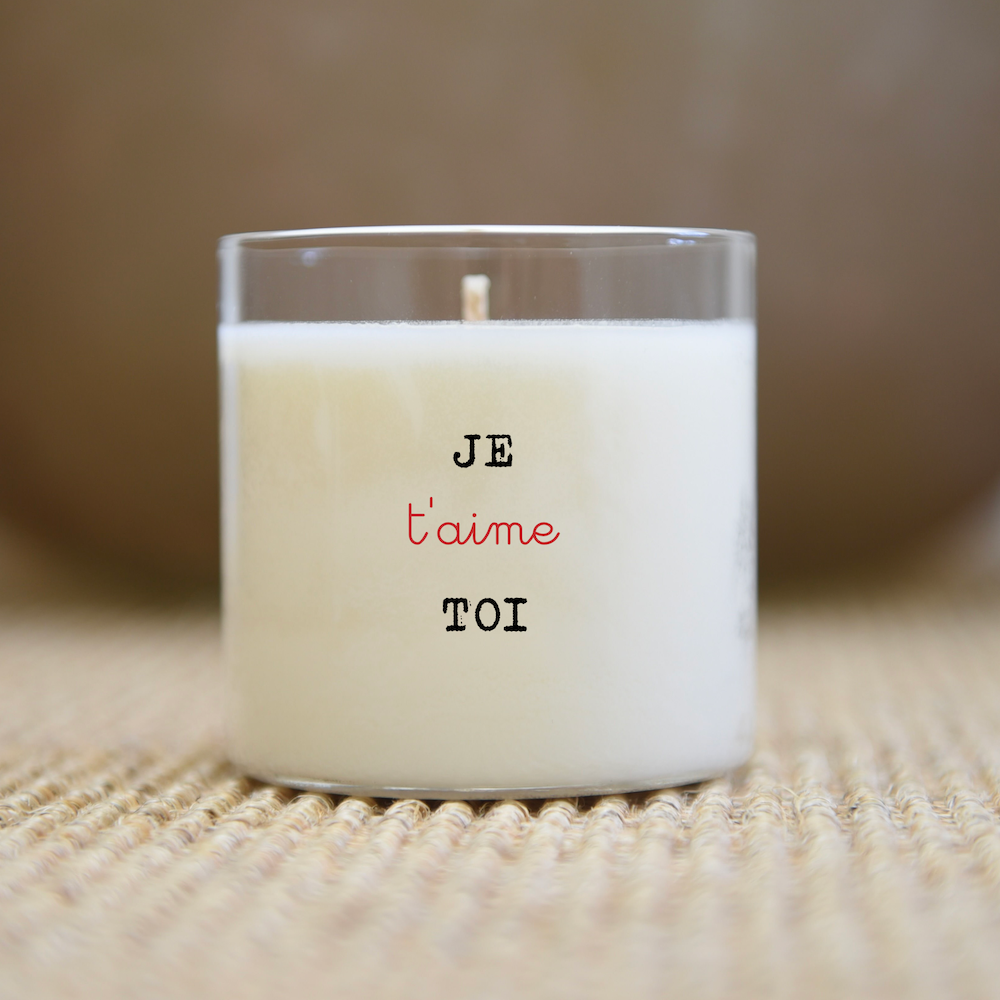 Bougie blanche dans un pot en verre transparent avec l'inscription