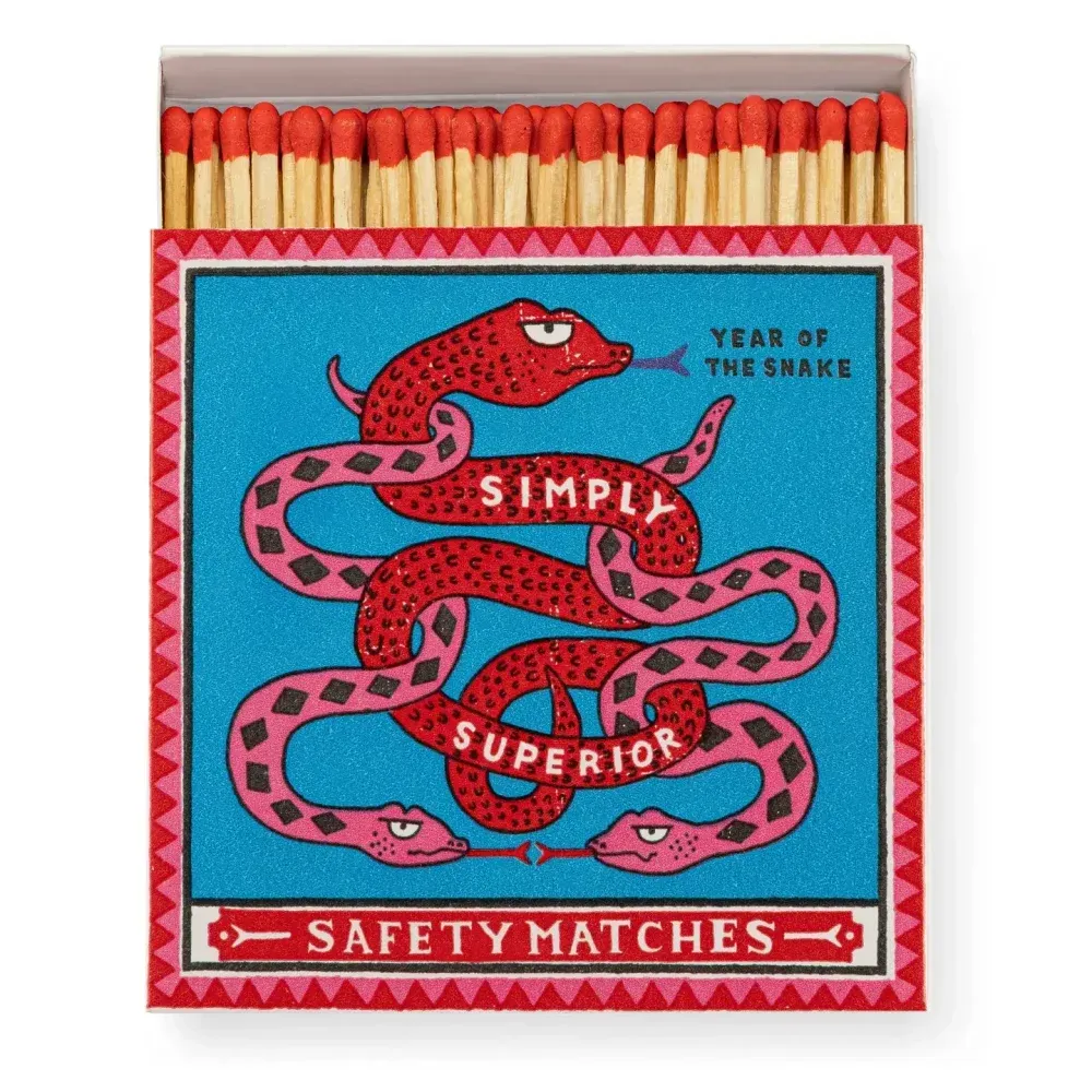 Boîte d'allumettes avec serpents rouges, fond bleu, texte « Allumettes de sécurité Simply Superior ».