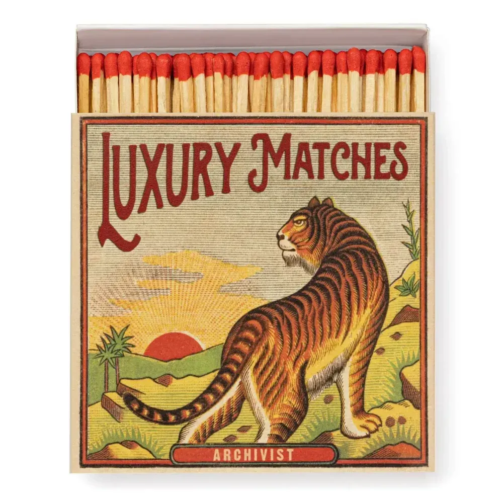 Boîte d'allumettes de luxe avec une illustration de tigre et des allumettes à pointe rouge.