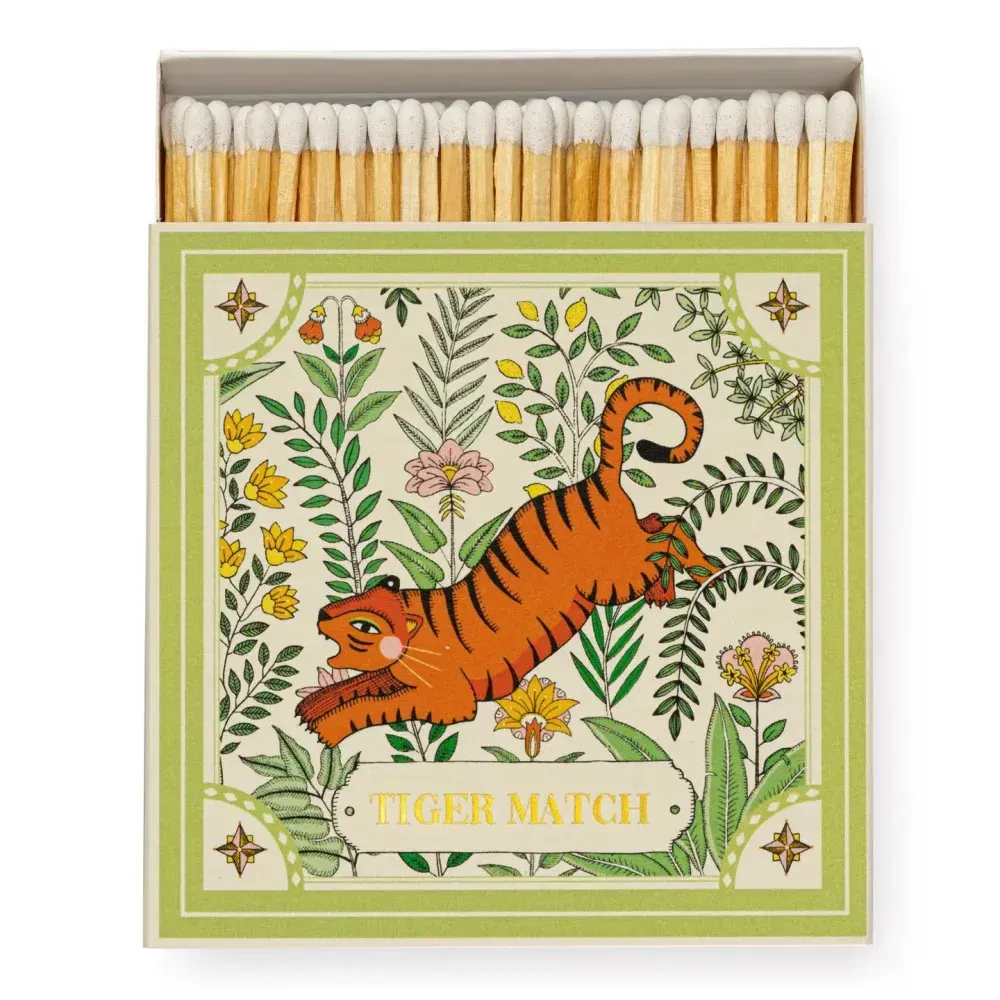 Boîte d'allumettes avec une illustration d'un tigre orange bondissant entouré de feuillage.