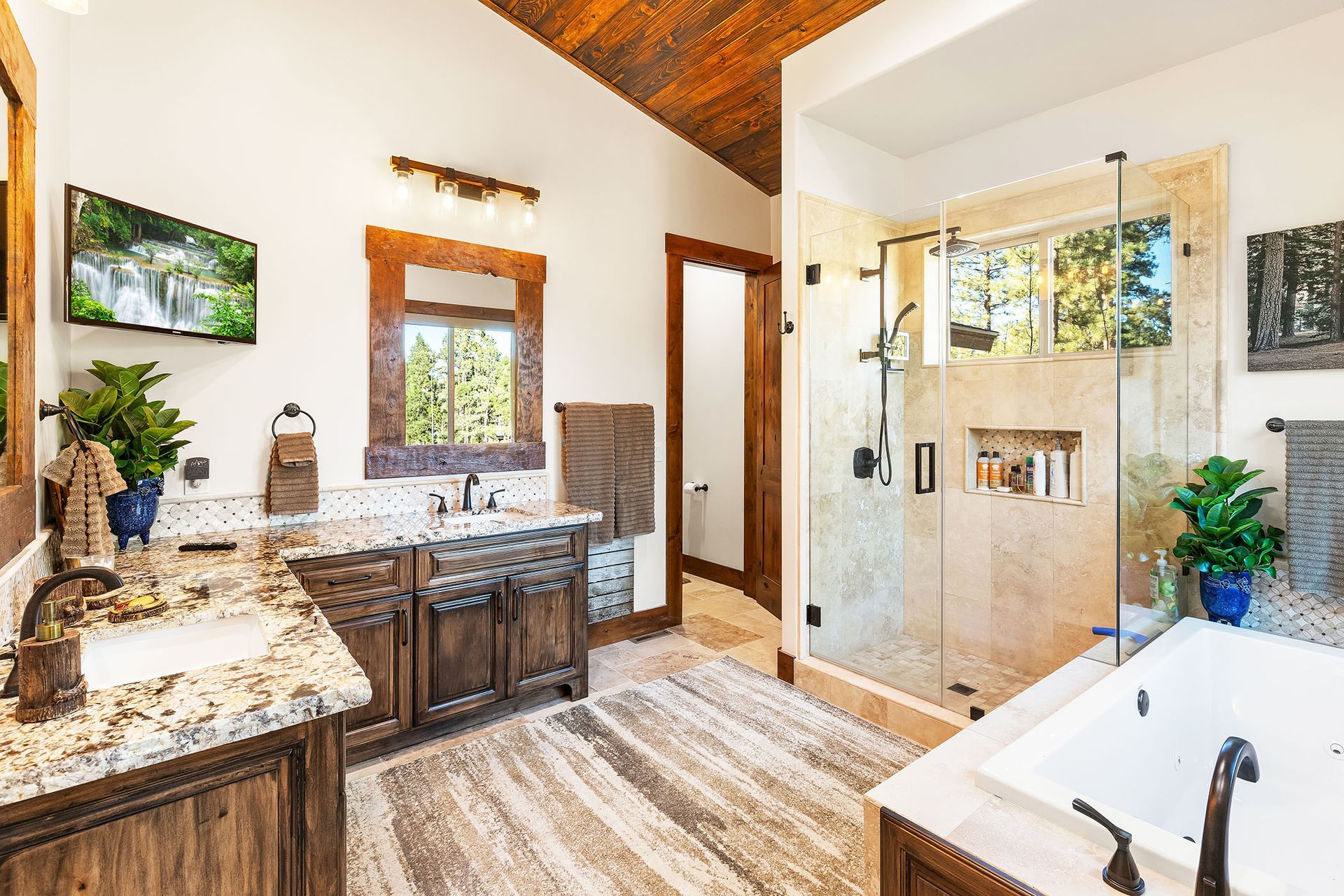 A bathroom with a tub , sink , mirror and shower.