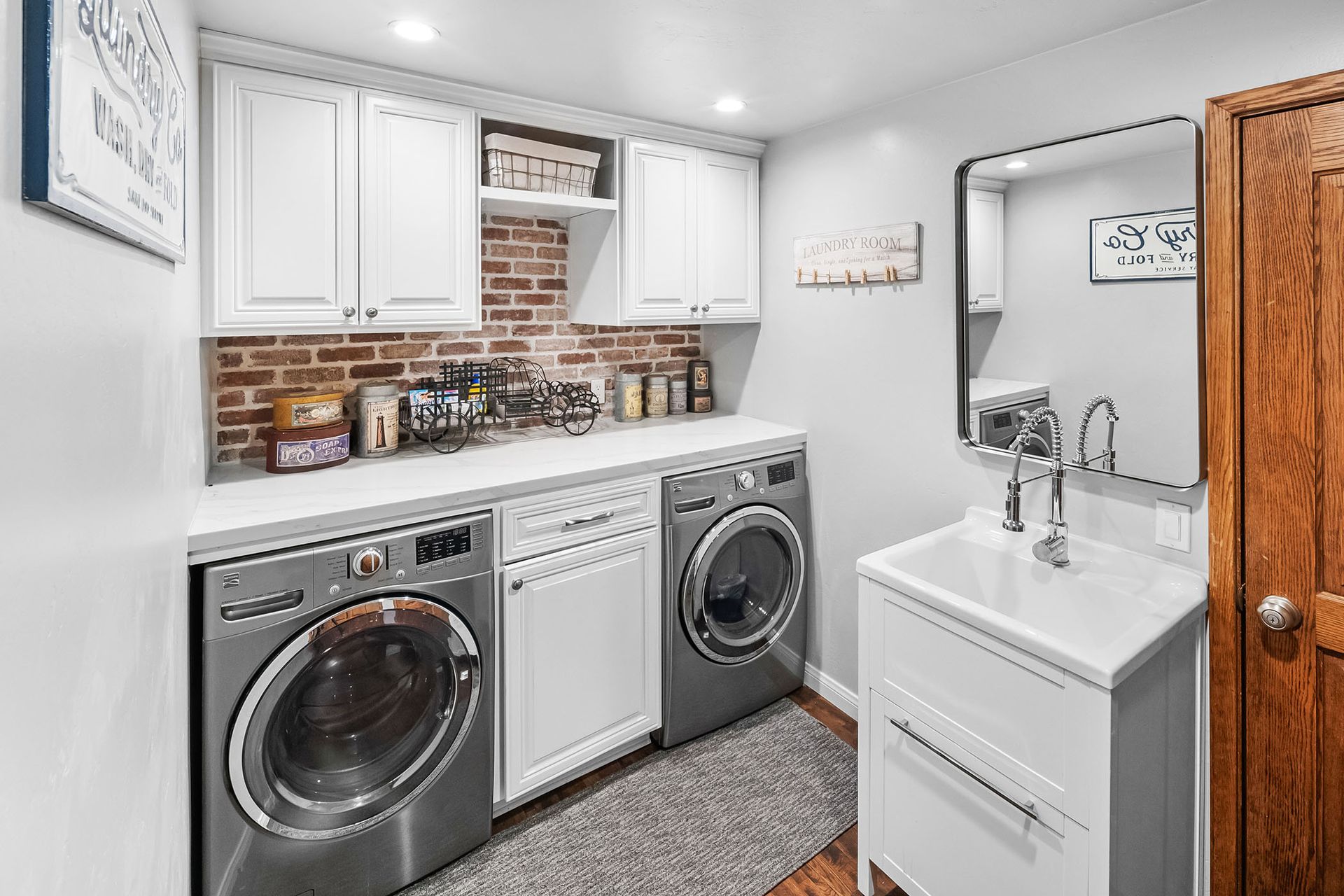 A laundry room with a washer and dryer and a sink.