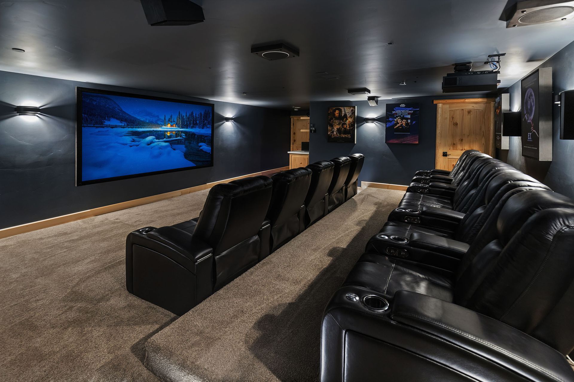A home theater with black leather seats and a large screen.