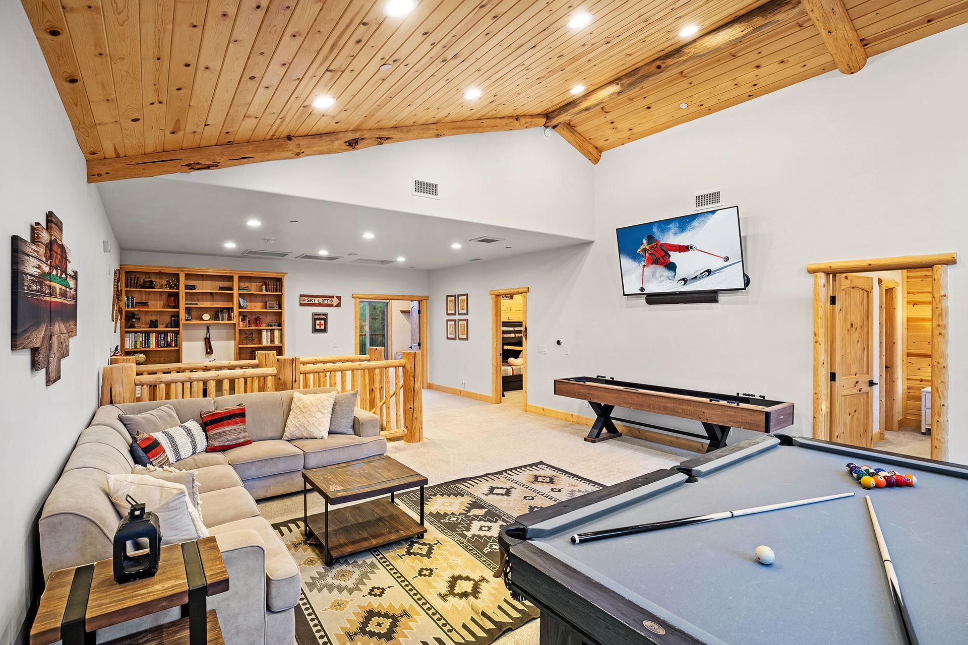 A living room with a pool table and a couch.