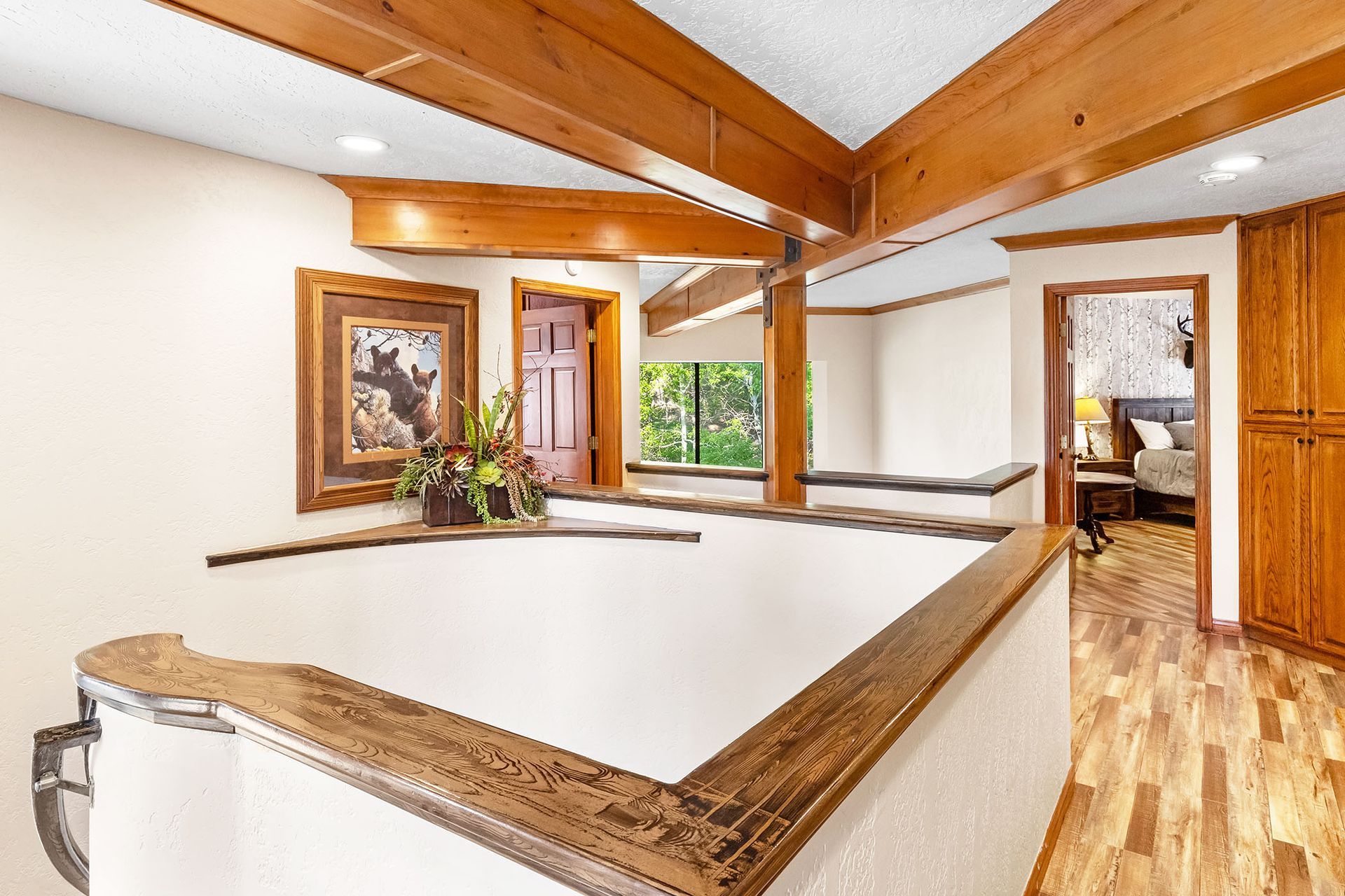 A hallway in a house with wooden beams and a wooden floor.