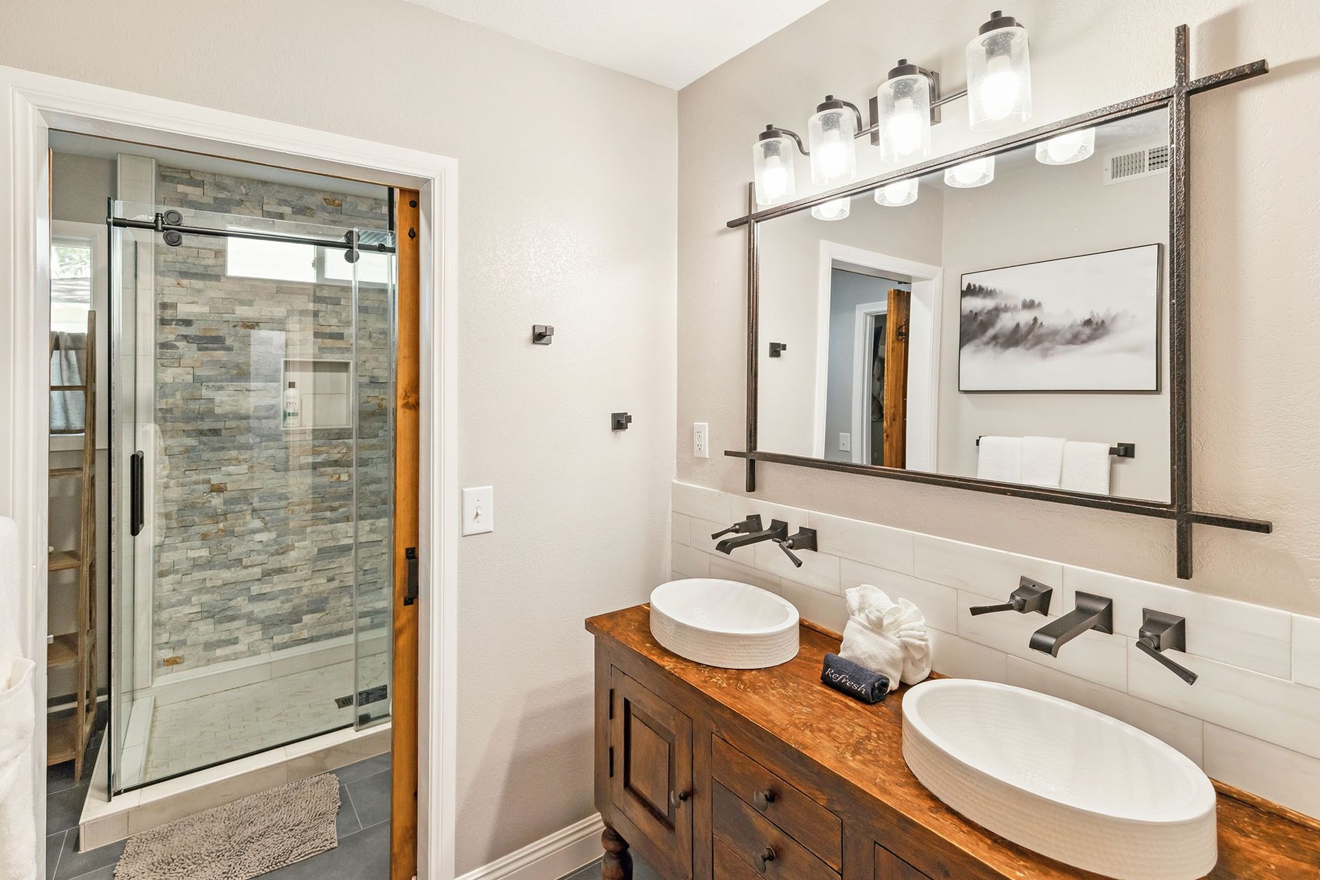 A bathroom with two sinks and a large mirror.