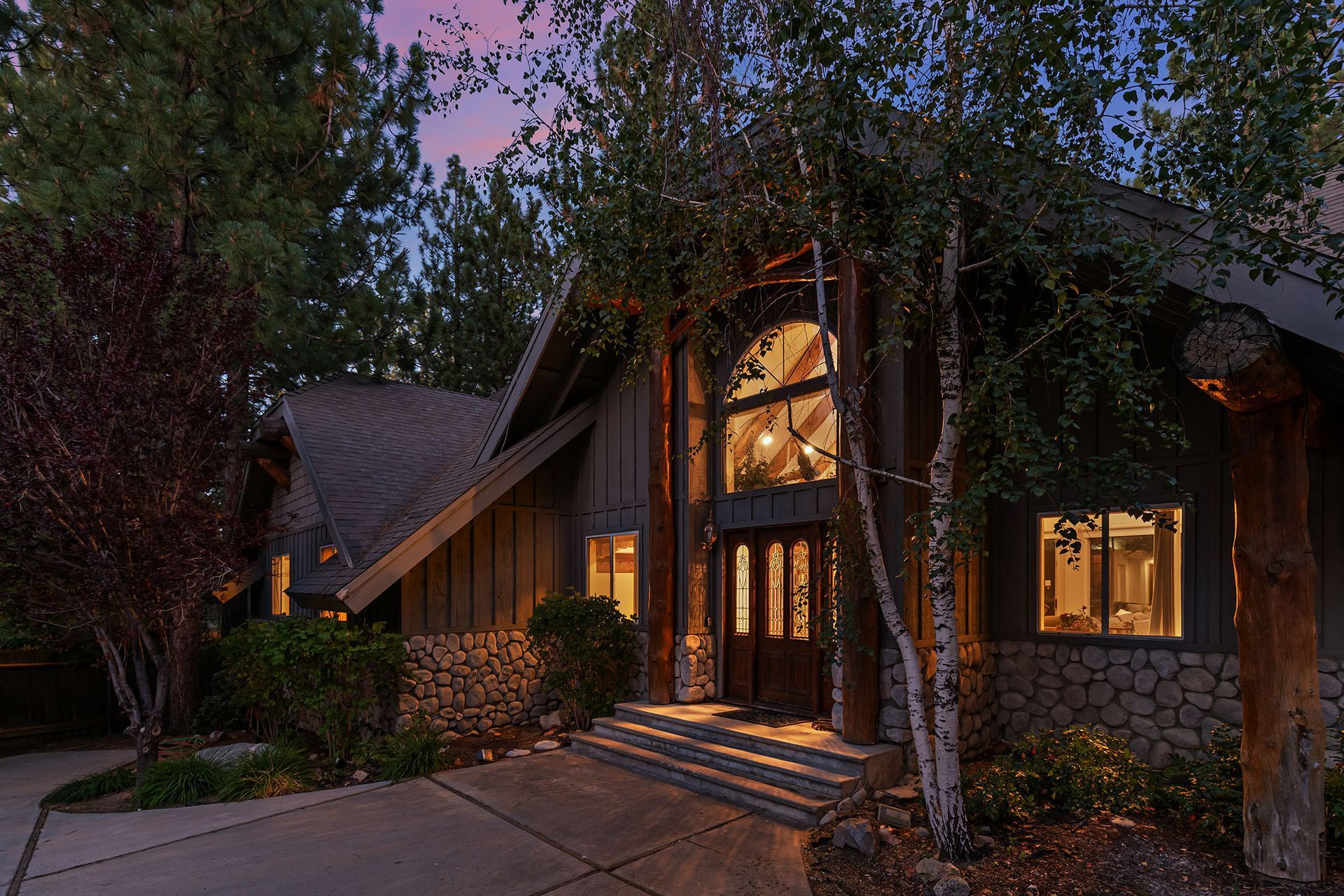 A large house with a lot of windows is lit up at night