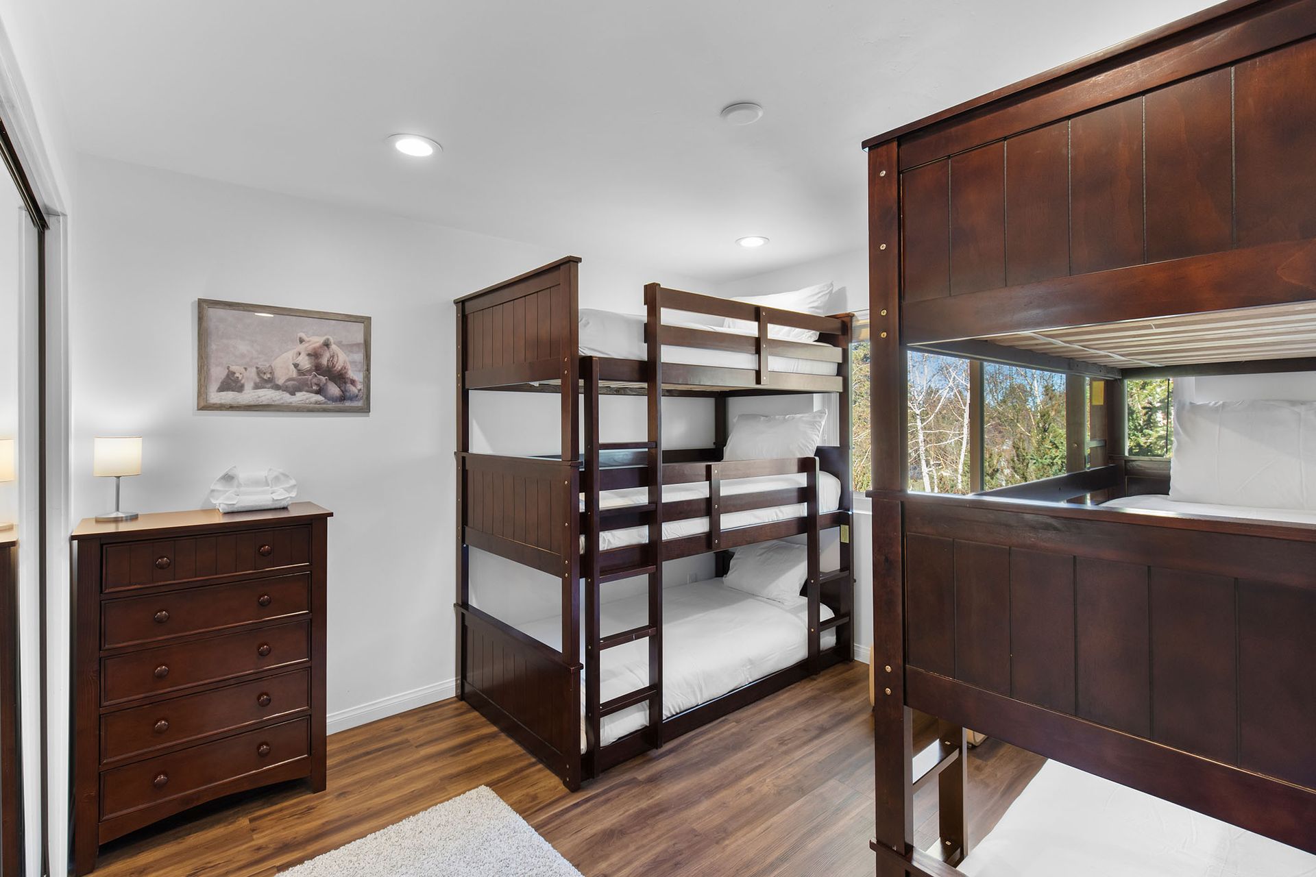A bedroom with two bunk beds and a dresser.