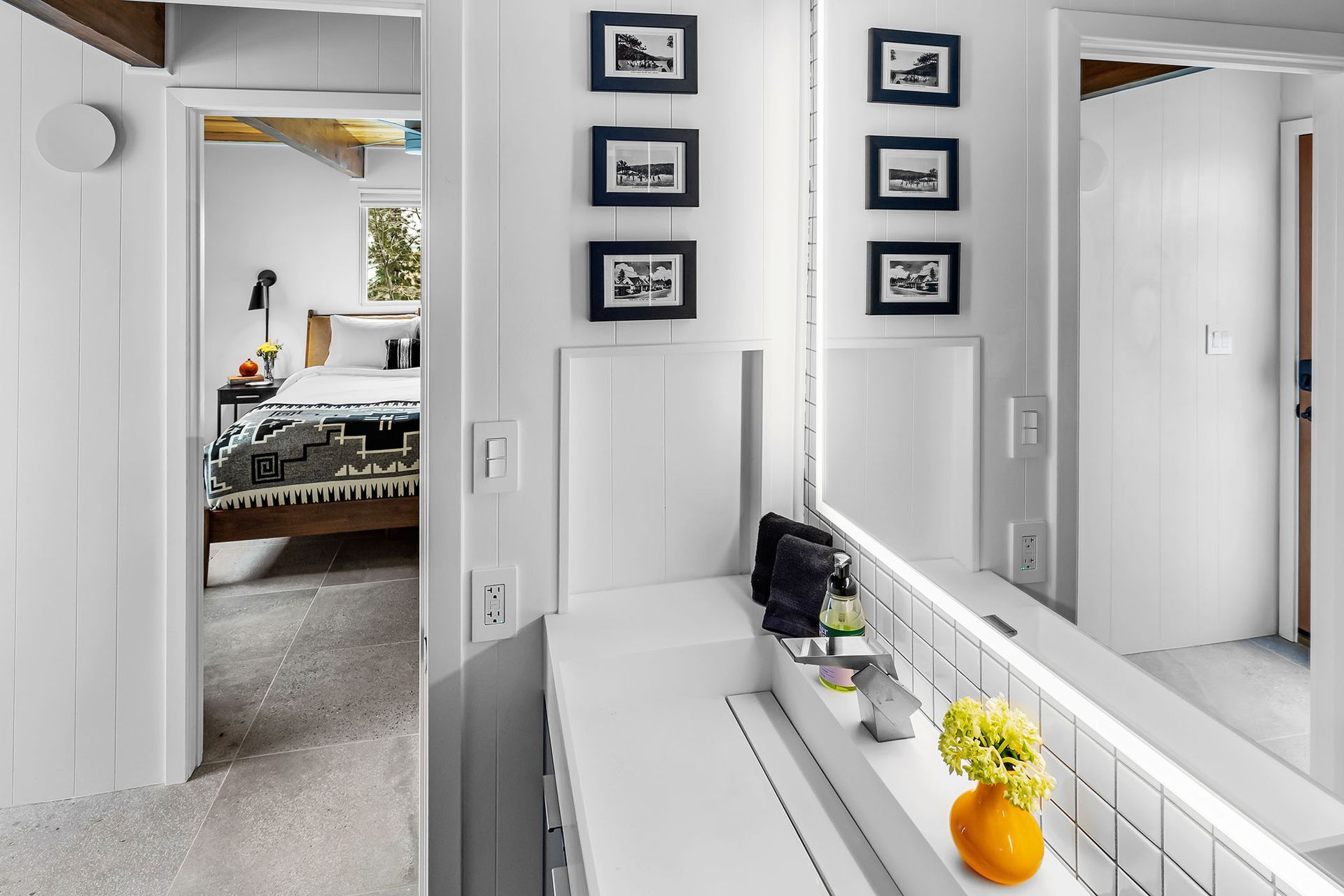 A bathroom with a vanity and a large mirror