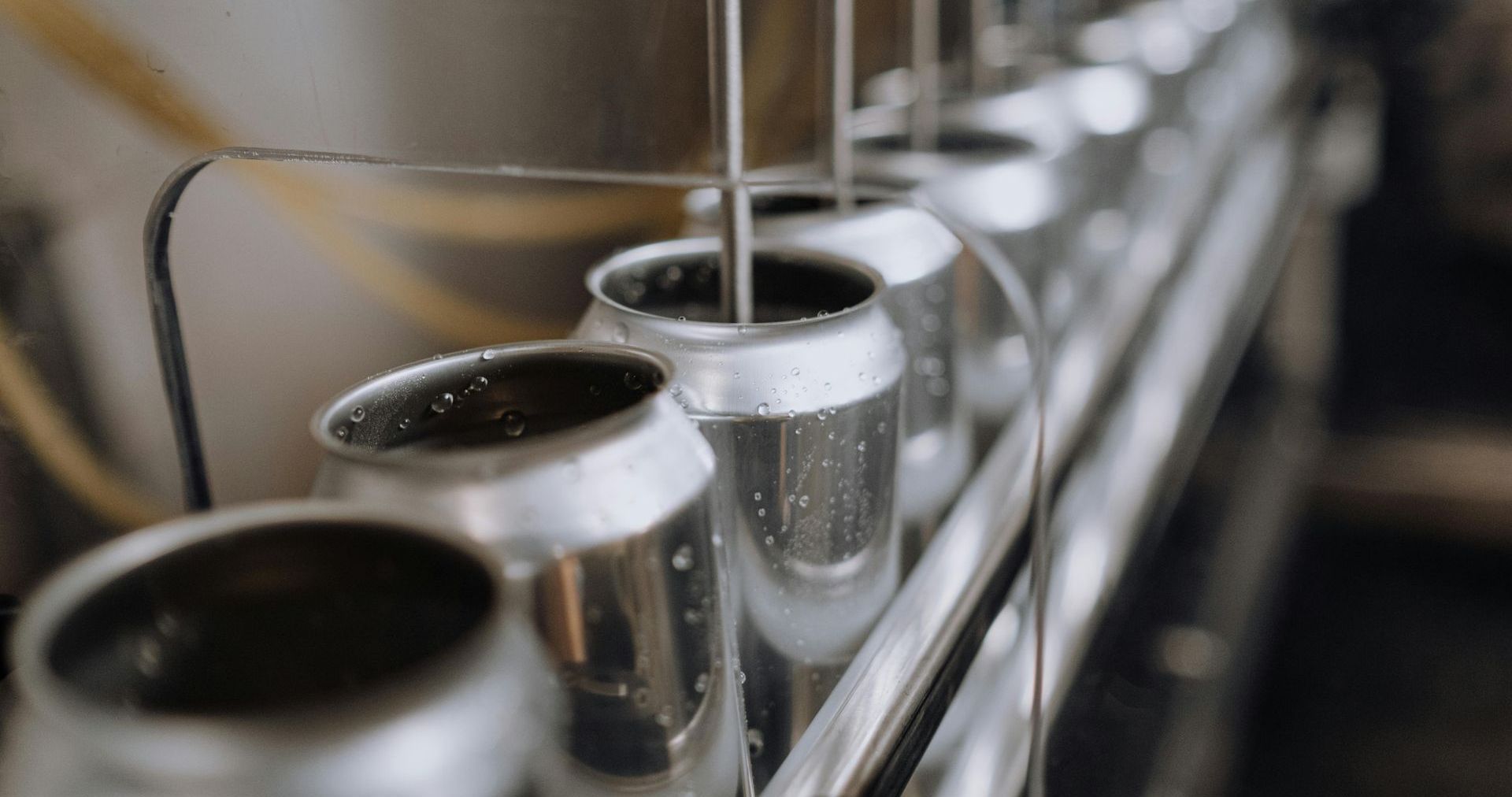 A row of cans sitting on top of a conveyor belt.