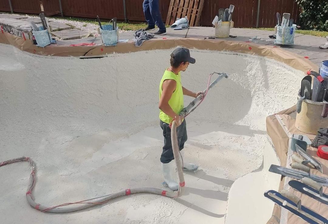 A man is using a vacuum cleaner to clean a pool.