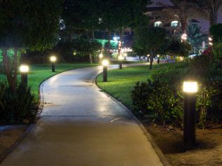 A person in a field uses a tablet to control a digital irrigation system overlay, demonstrating smart farming technology.
