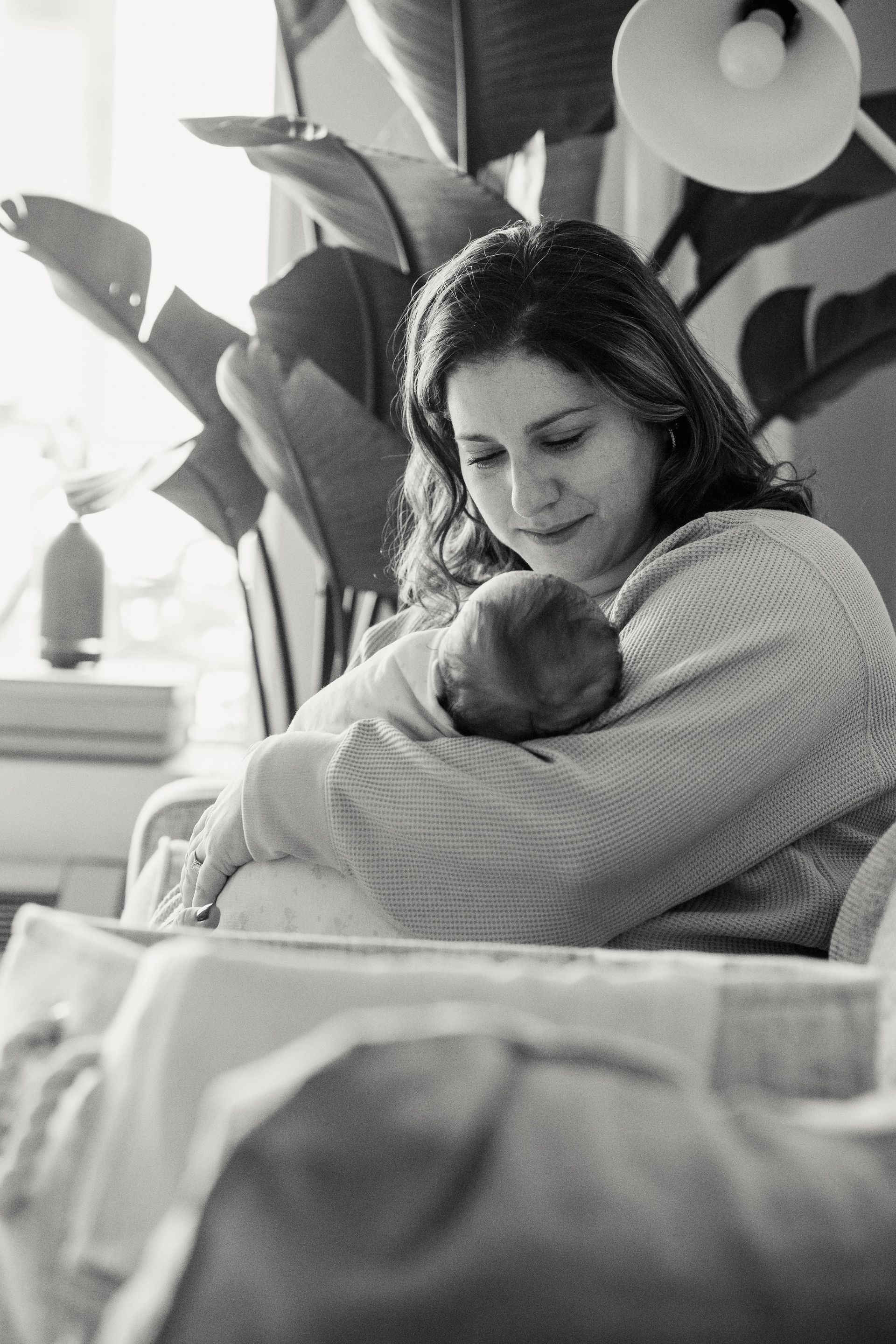 A woman is holding a baby in her arms in a black and white photo.