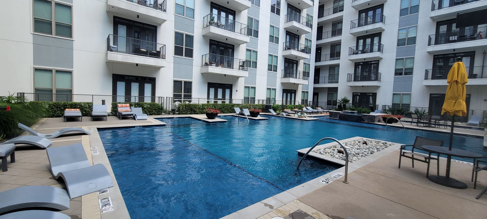 There is a large swimming pool in the middle of a building.