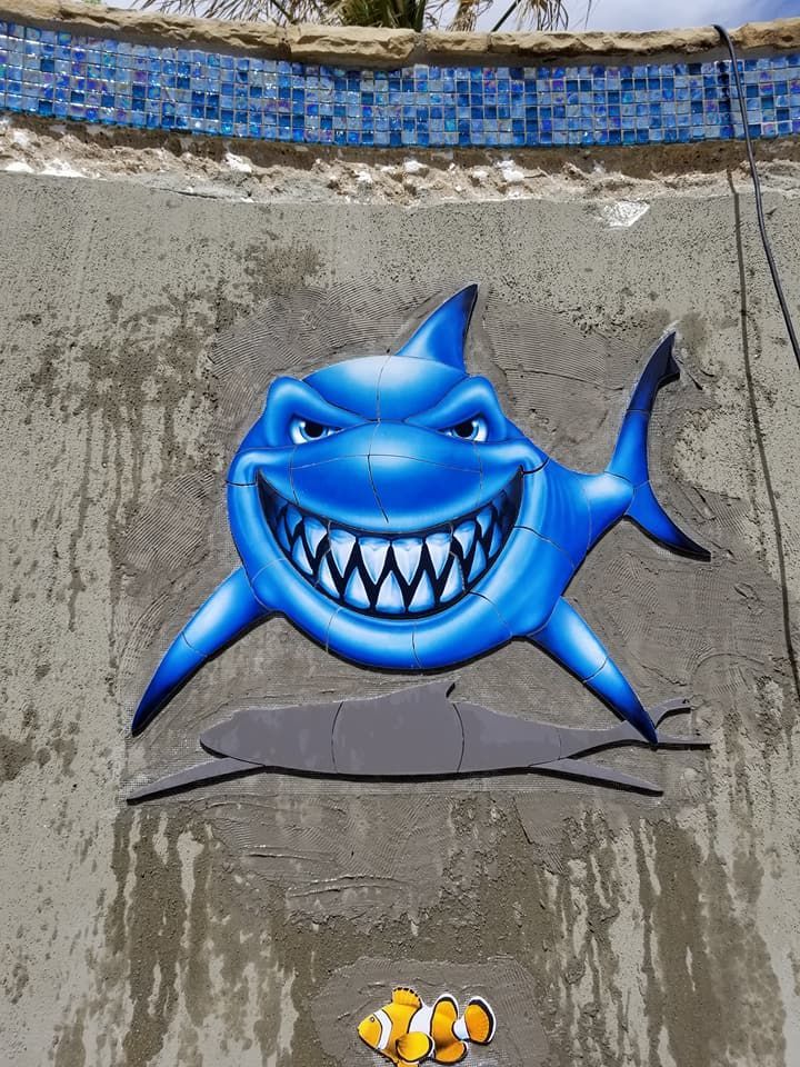 A blue shark is smiling next to a clown fish