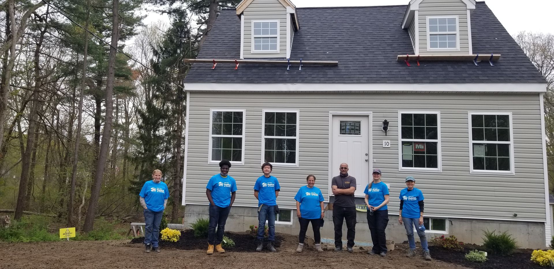 A group of people standing in front of a house