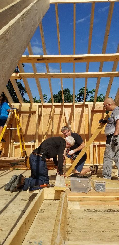 A group of men are working on a wooden structure.