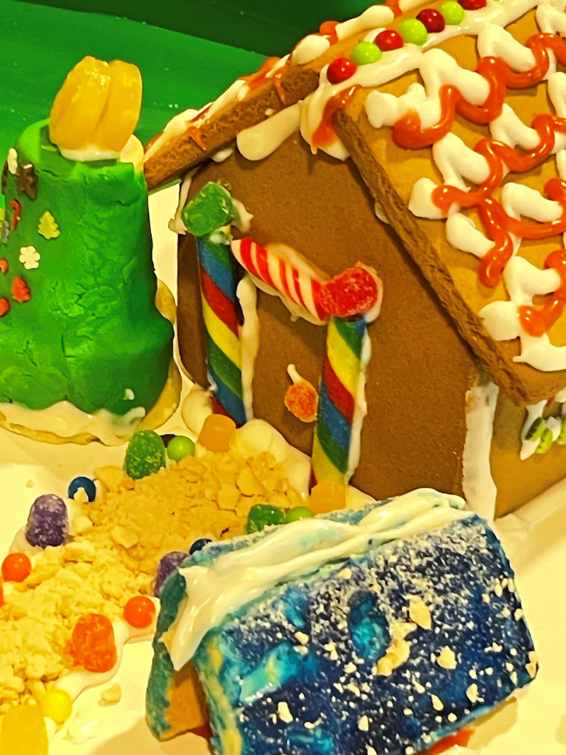 A gingerbread house is decorated with candy canes and frosting