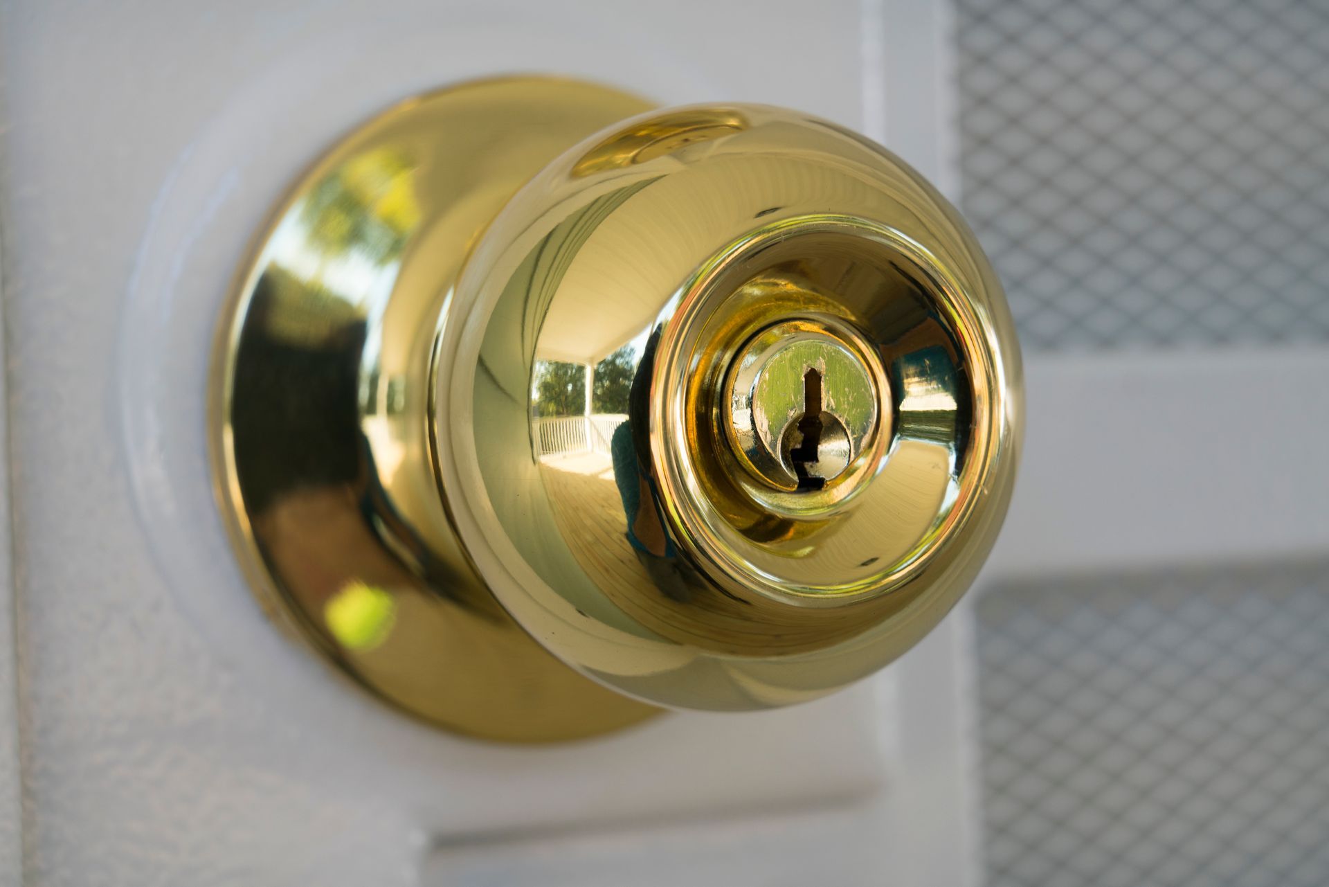A gold door knob with a key in it