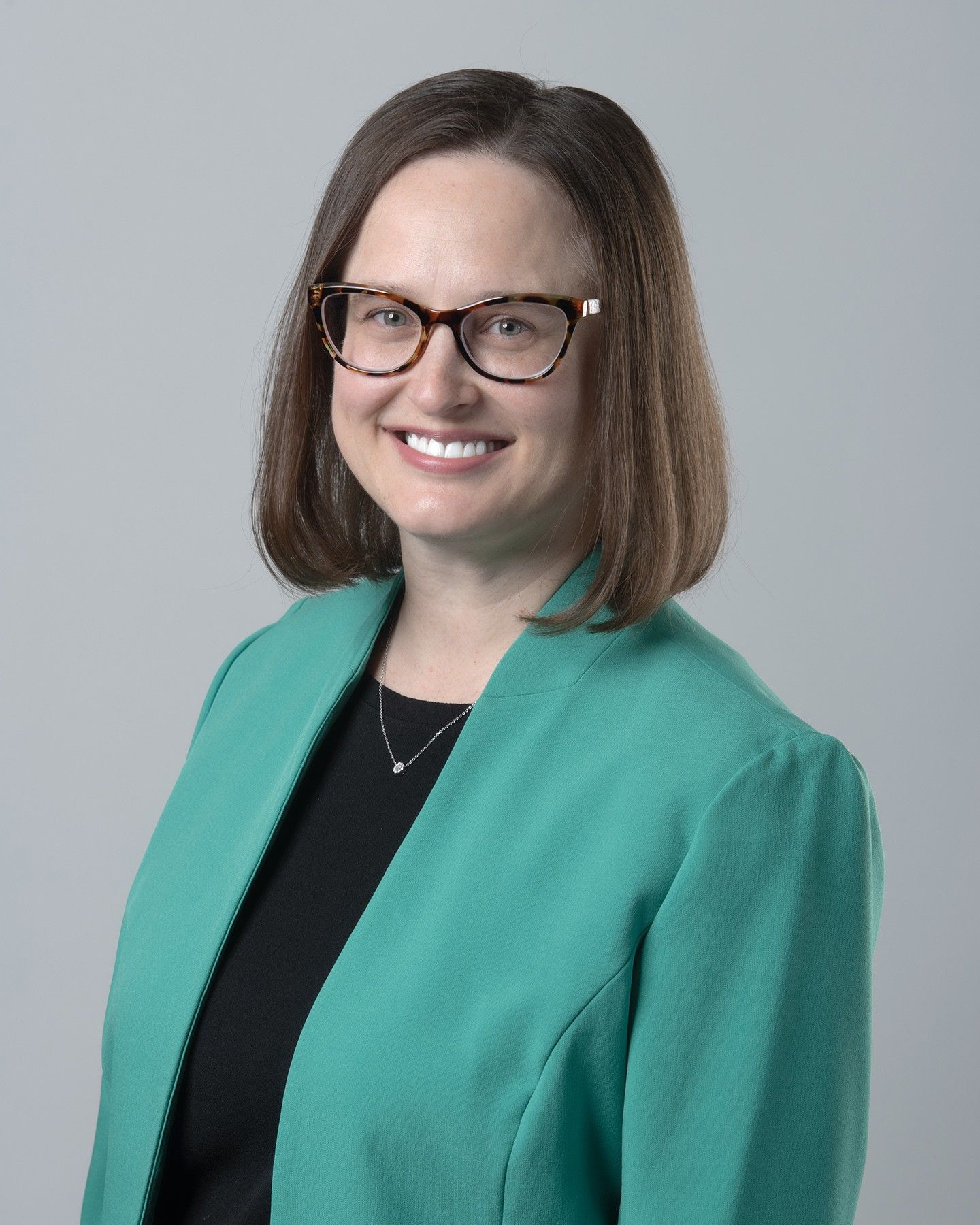 A woman wearing a black jacket is smiling for the camera