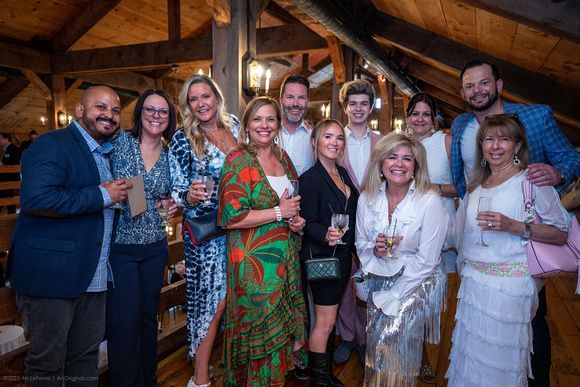 A group of people are posing for a picture while holding wine glasses.