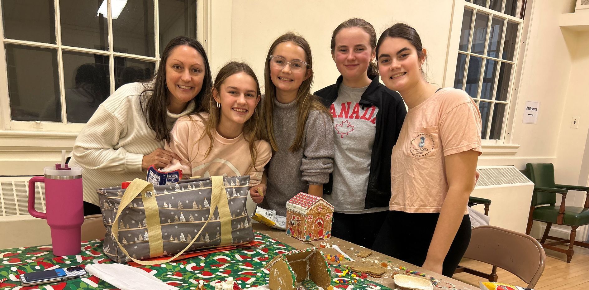 A group of girls are posing for a picture in front of a table