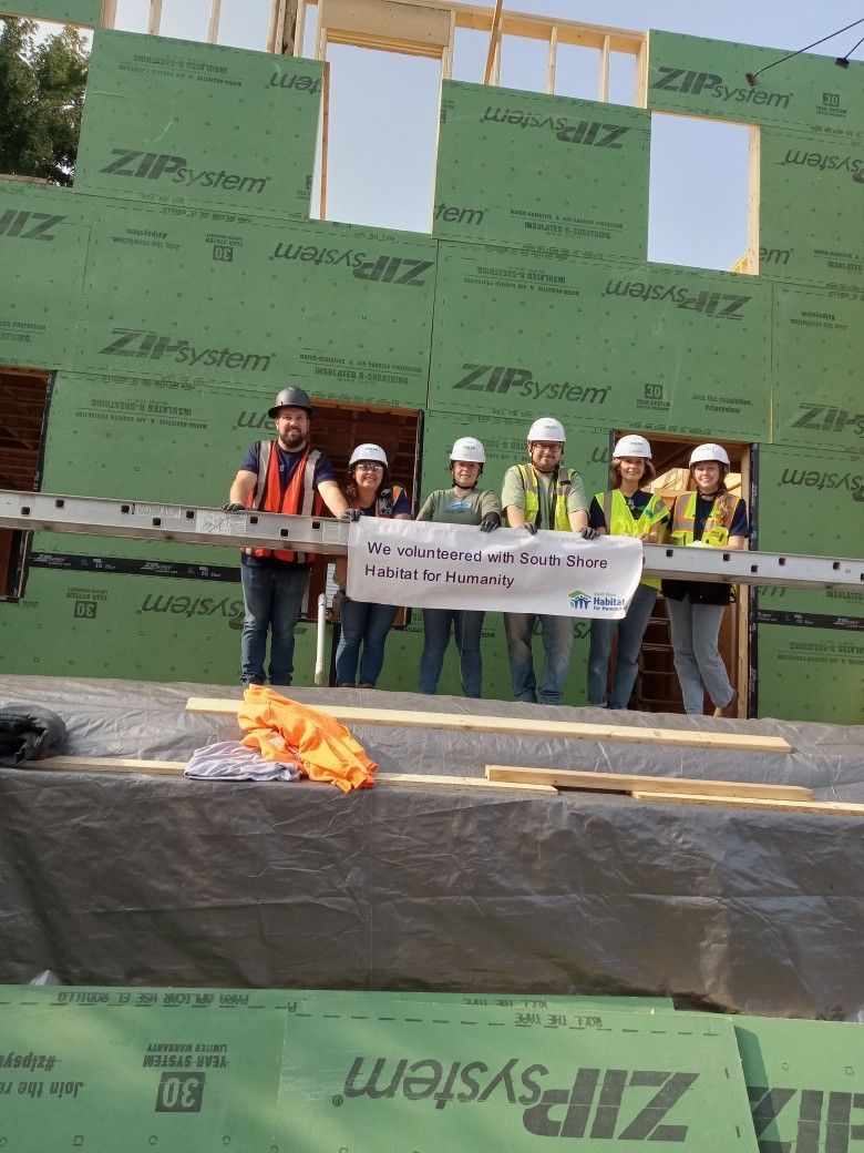 A group of construction workers holding a sign that says zip system