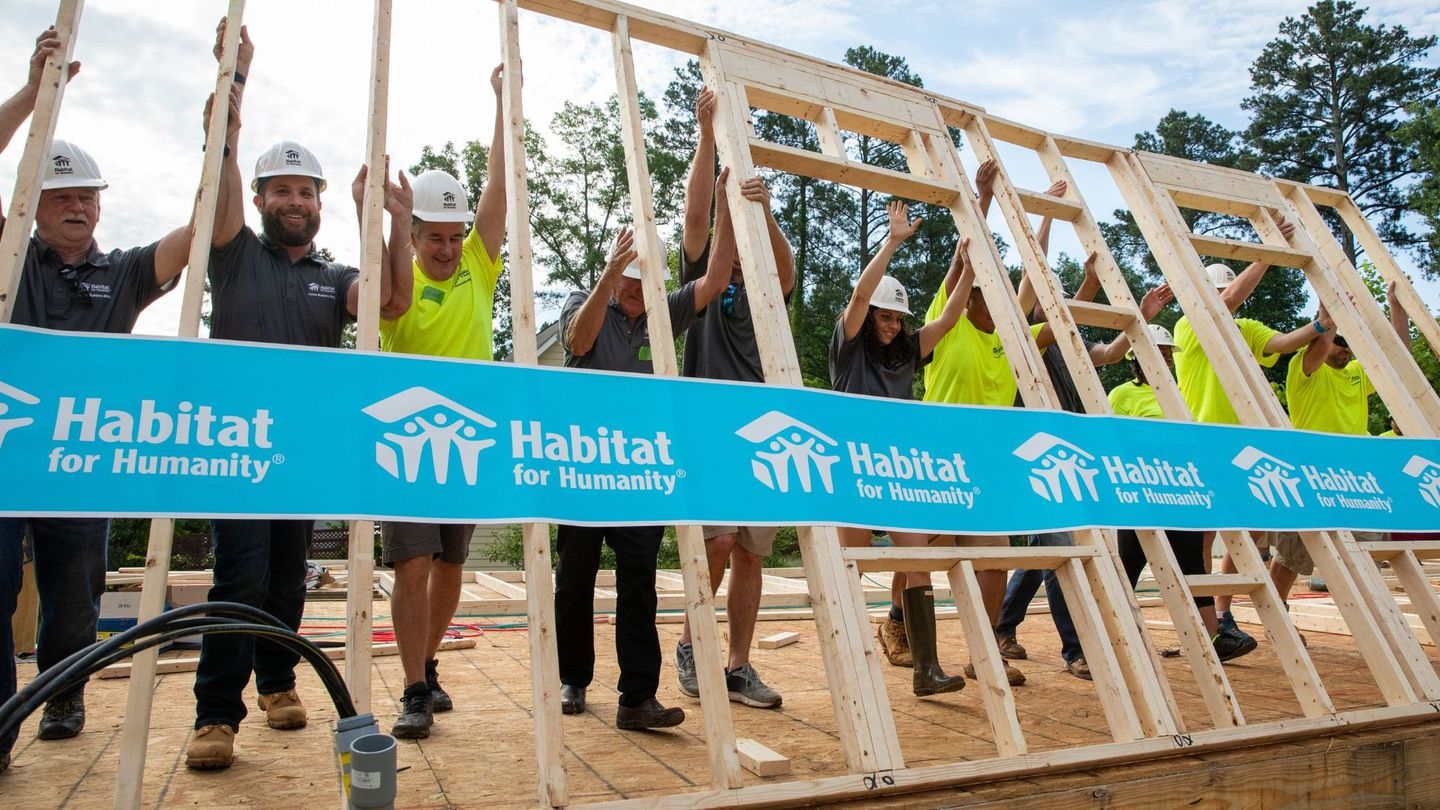 A group of people holding up a habitat for humanity banner