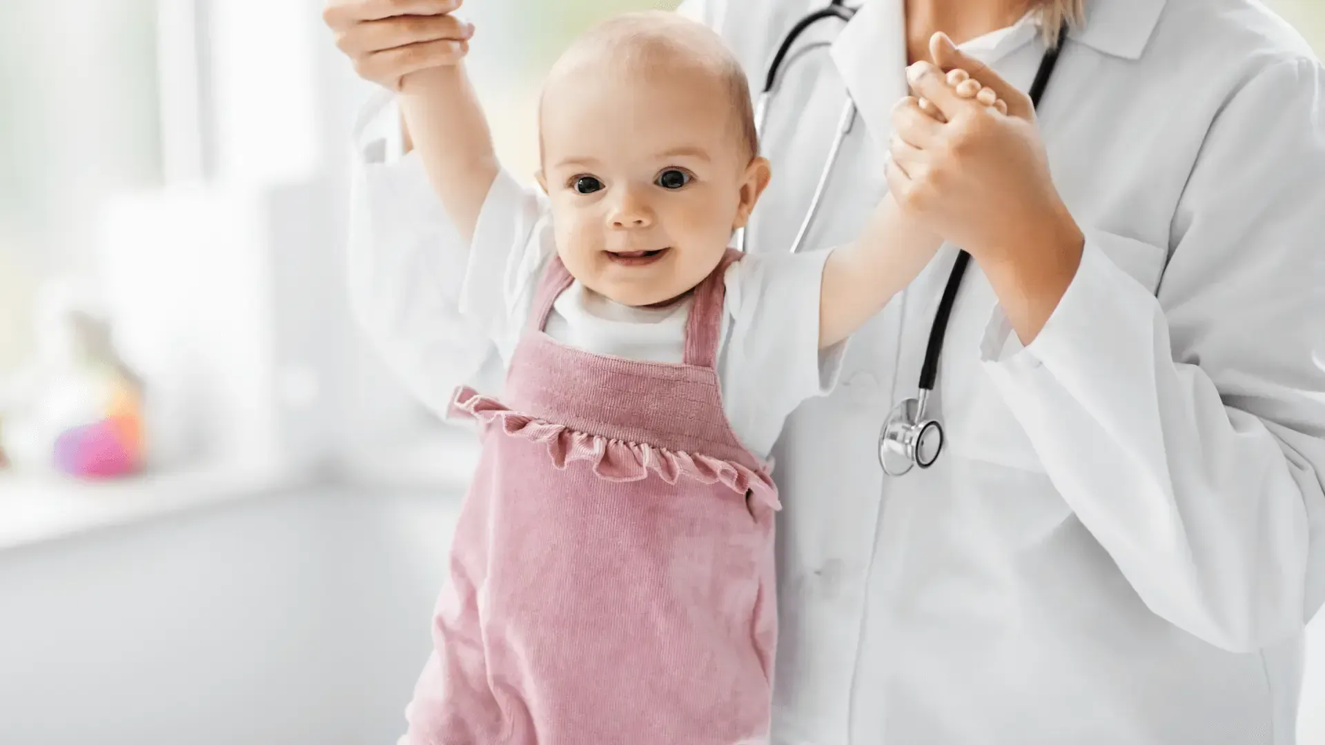 Un médecin tient une petite fille dans ses bras.