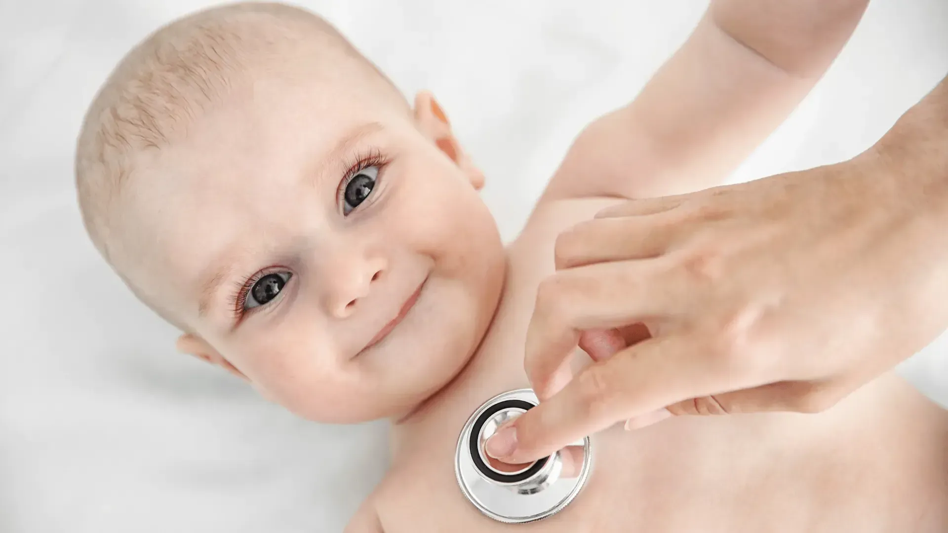 Un bébé est examiné par un médecin avec un stéthoscope.
