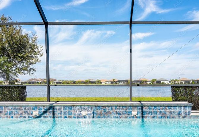 A swimming pool with a view of a lake through a screen.