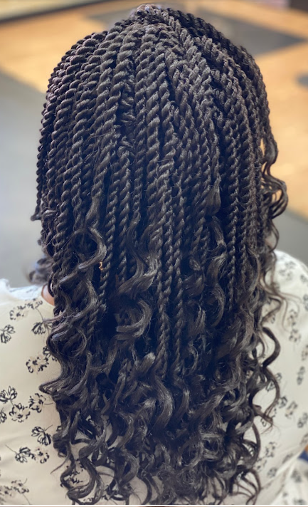 Black hair styled in twists with curly ends.