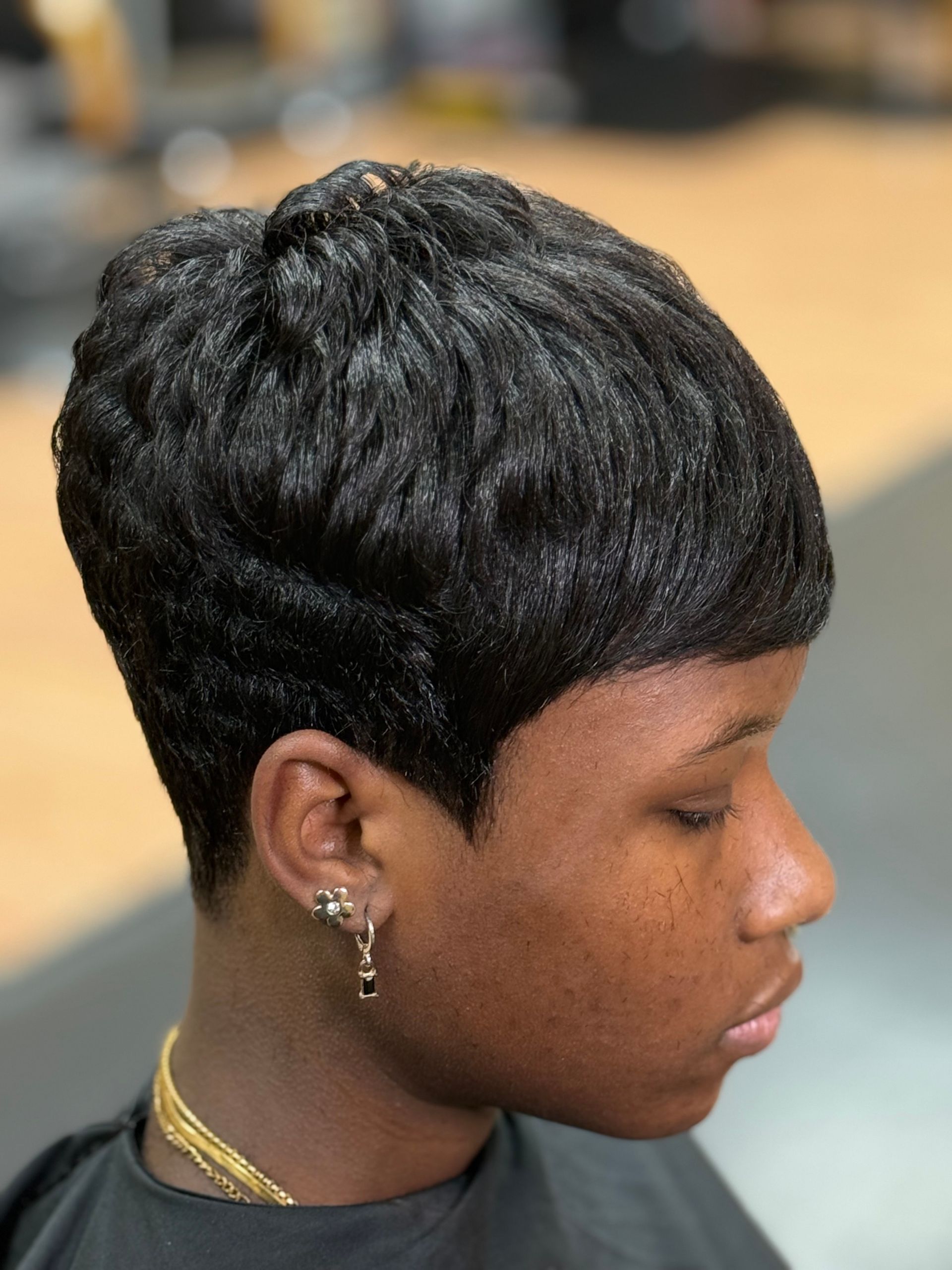 Woman with short, black, textured pixie cut hairstyle.
