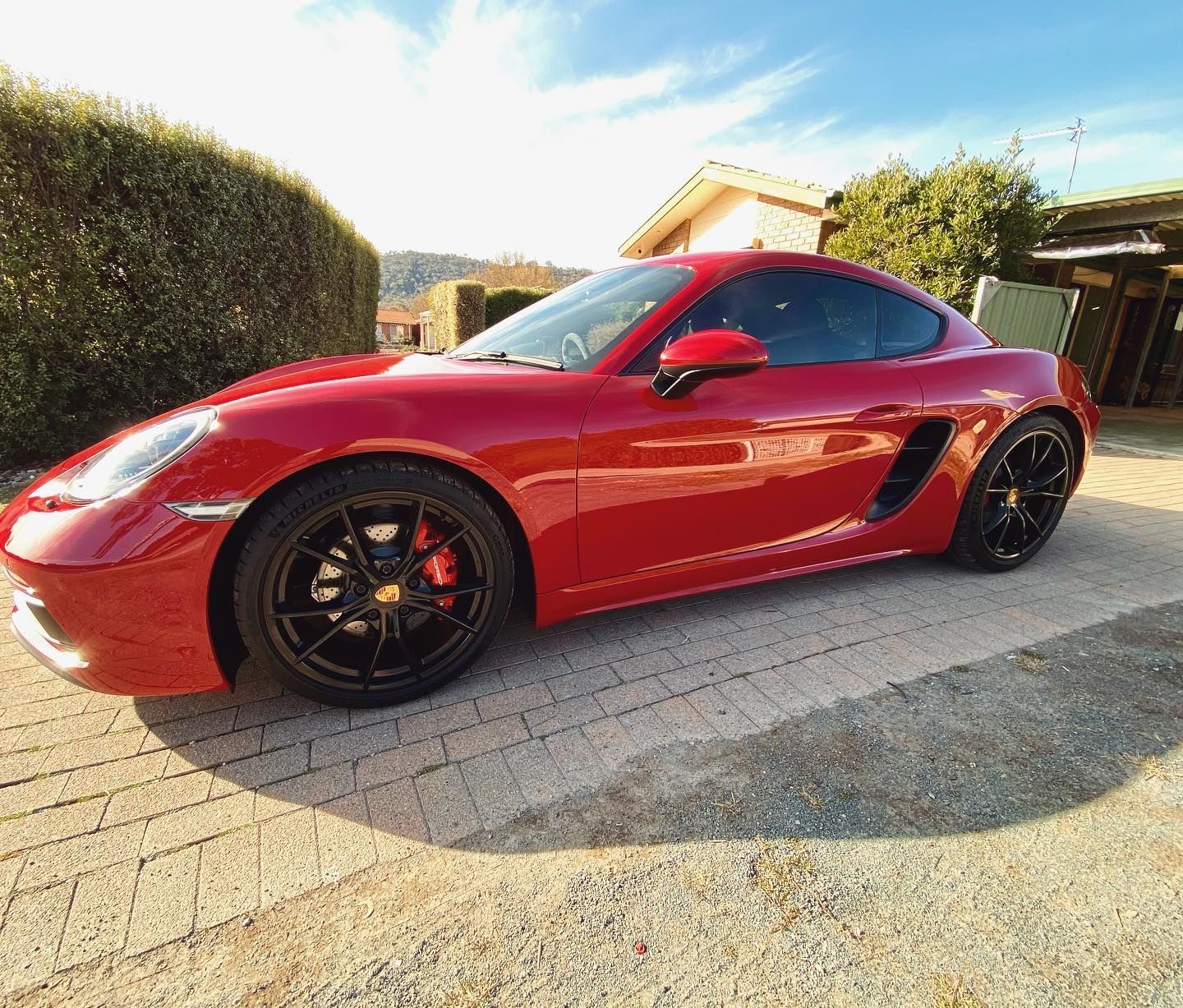 A Red Sports Car is Parked in a Driveway in Front of a House — Diamond Tints In Woden, ACT