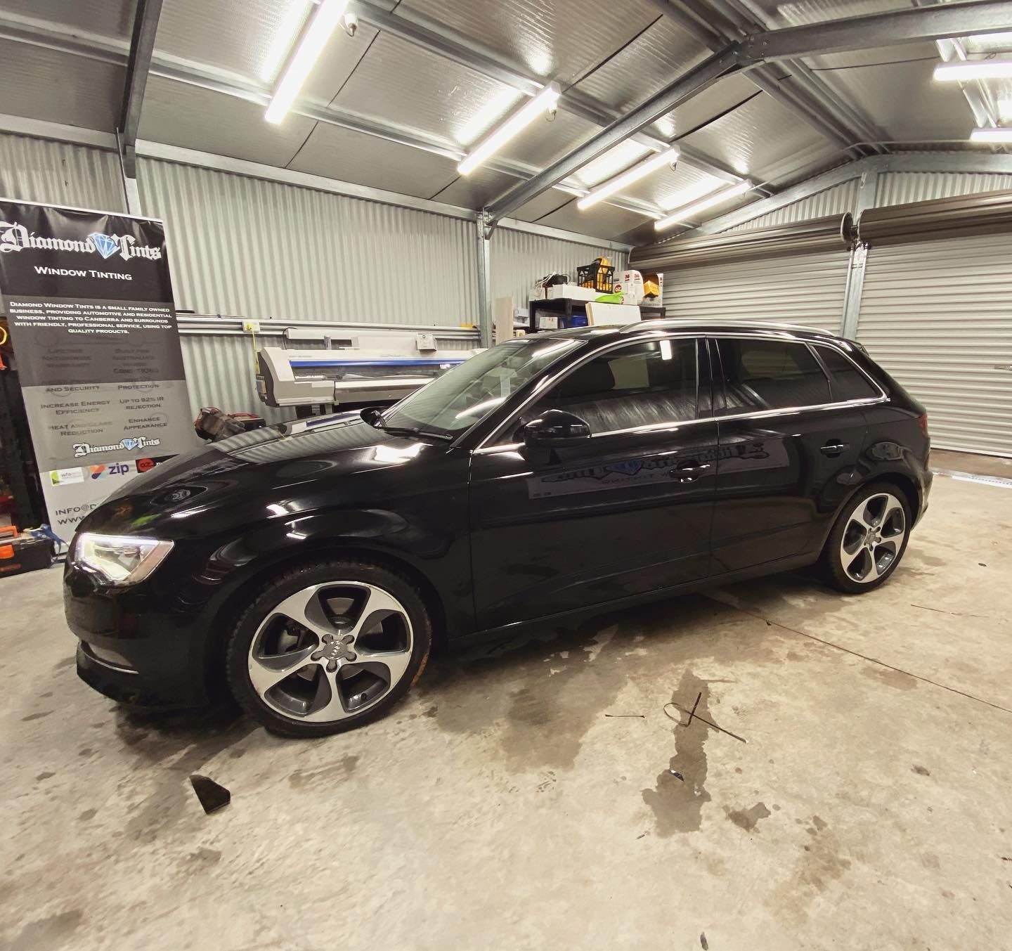 A Black Car is Parked Inside of a Garage —	Diamond Tints In Phillip, ACT