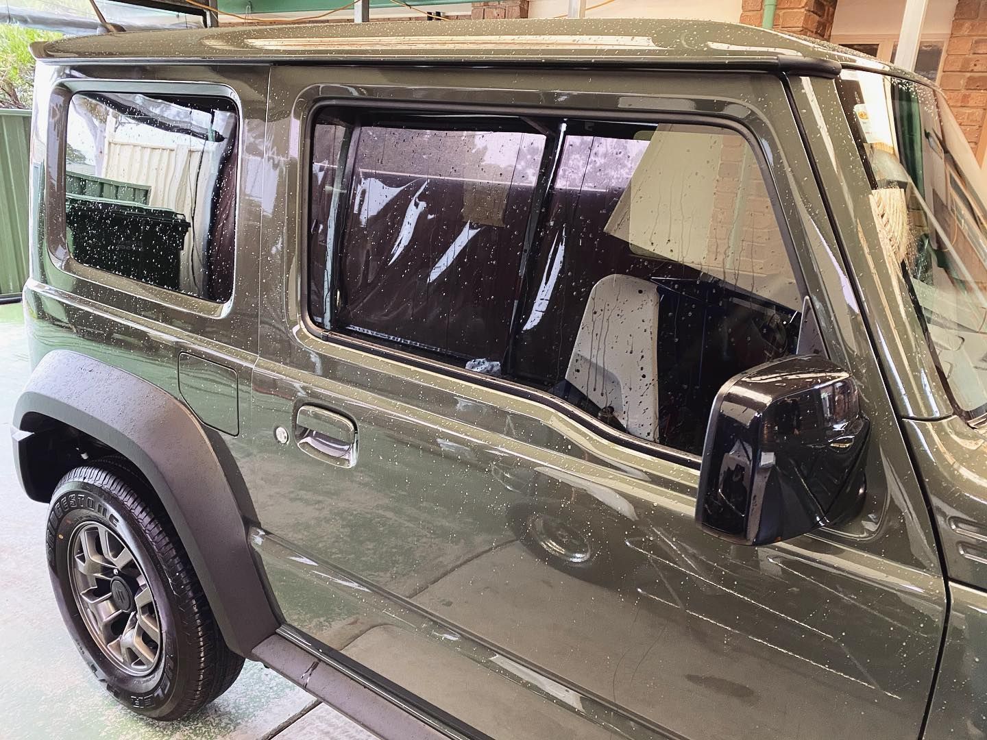A Green Jeep is Parked in a Driveway in Front of a Building — Diamond Tints In Gungahlin, ACT