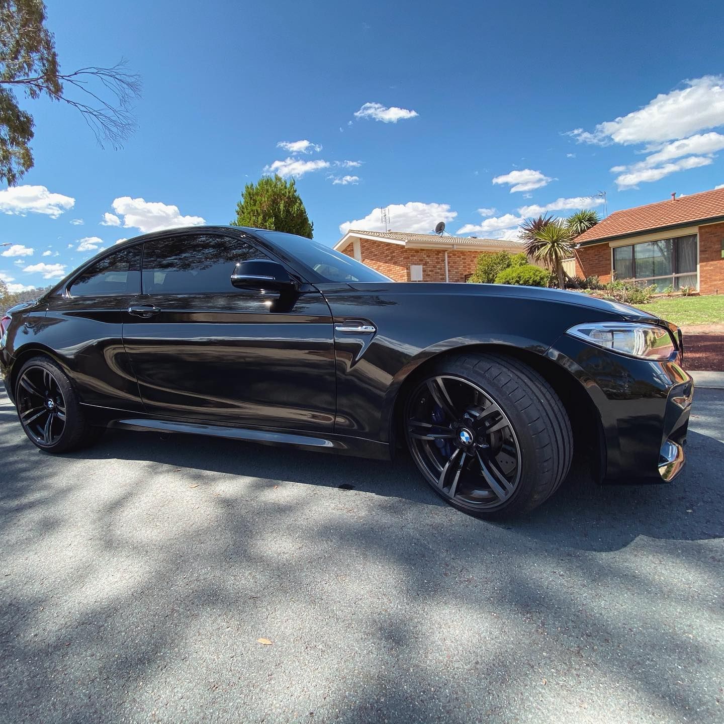 A Black BMW M2 is Parked on the Side of the Road — Diamond Tints In Phillip, ACT