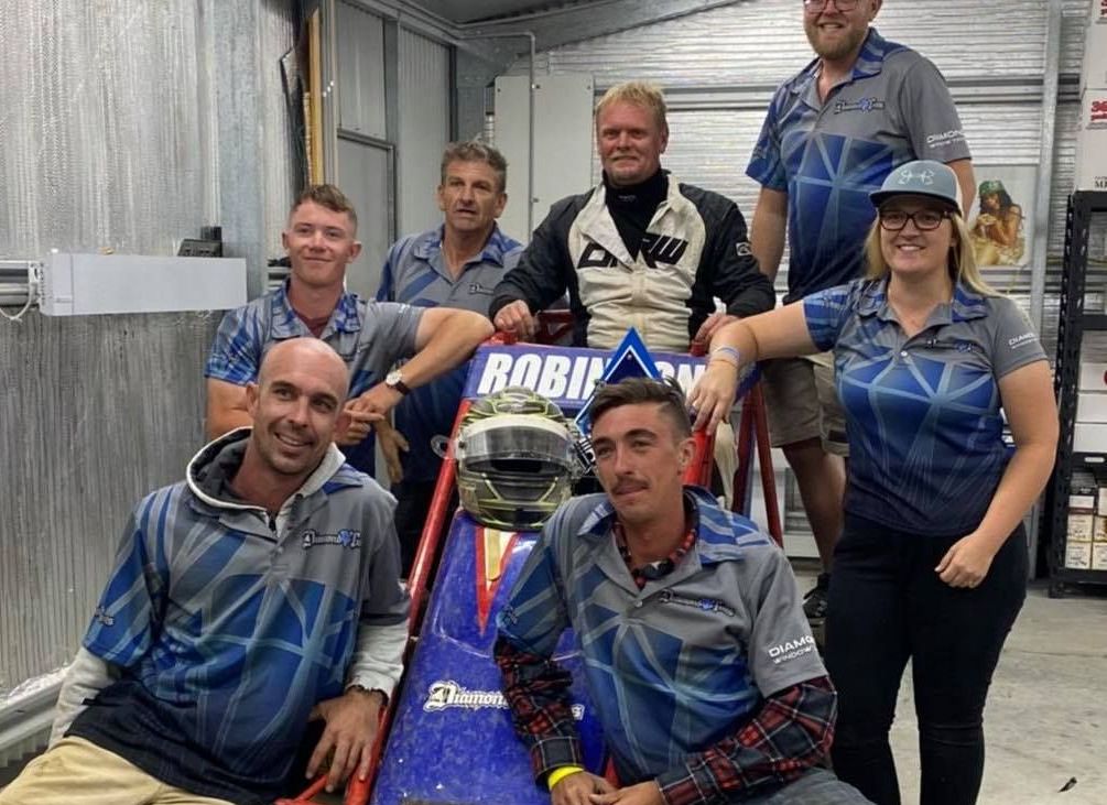 A Group of People Standing Around a Race Car — Diamond Tints In Phillip, ACT