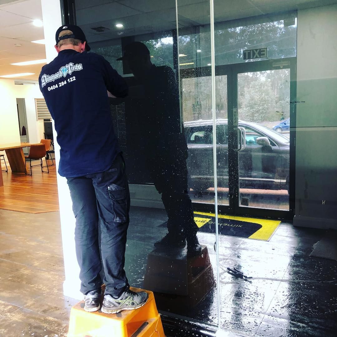 A Man Wearing a Blue Shirt Installing Tints — Diamond Tints In Phillip, ACT