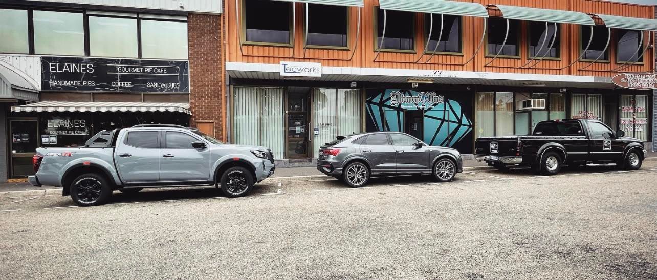Three Pickup Trucks Are Parked in Front of a Building — Diamond Tints In Phillip, ACT
