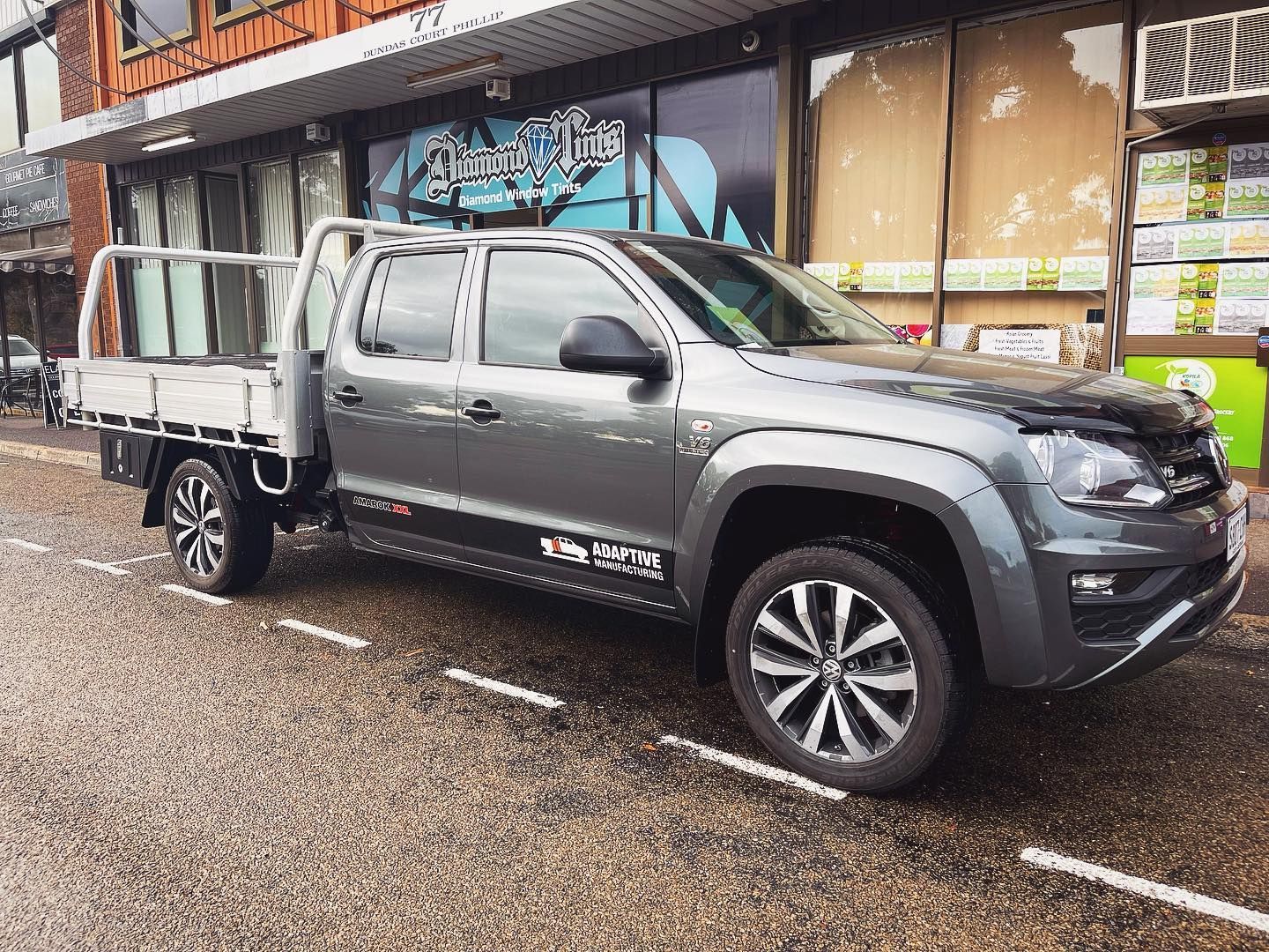 A Volkswagen Amarok is Parked in a Parking Lot in Front of a Building — Diamond Tints In Phillip, ACT