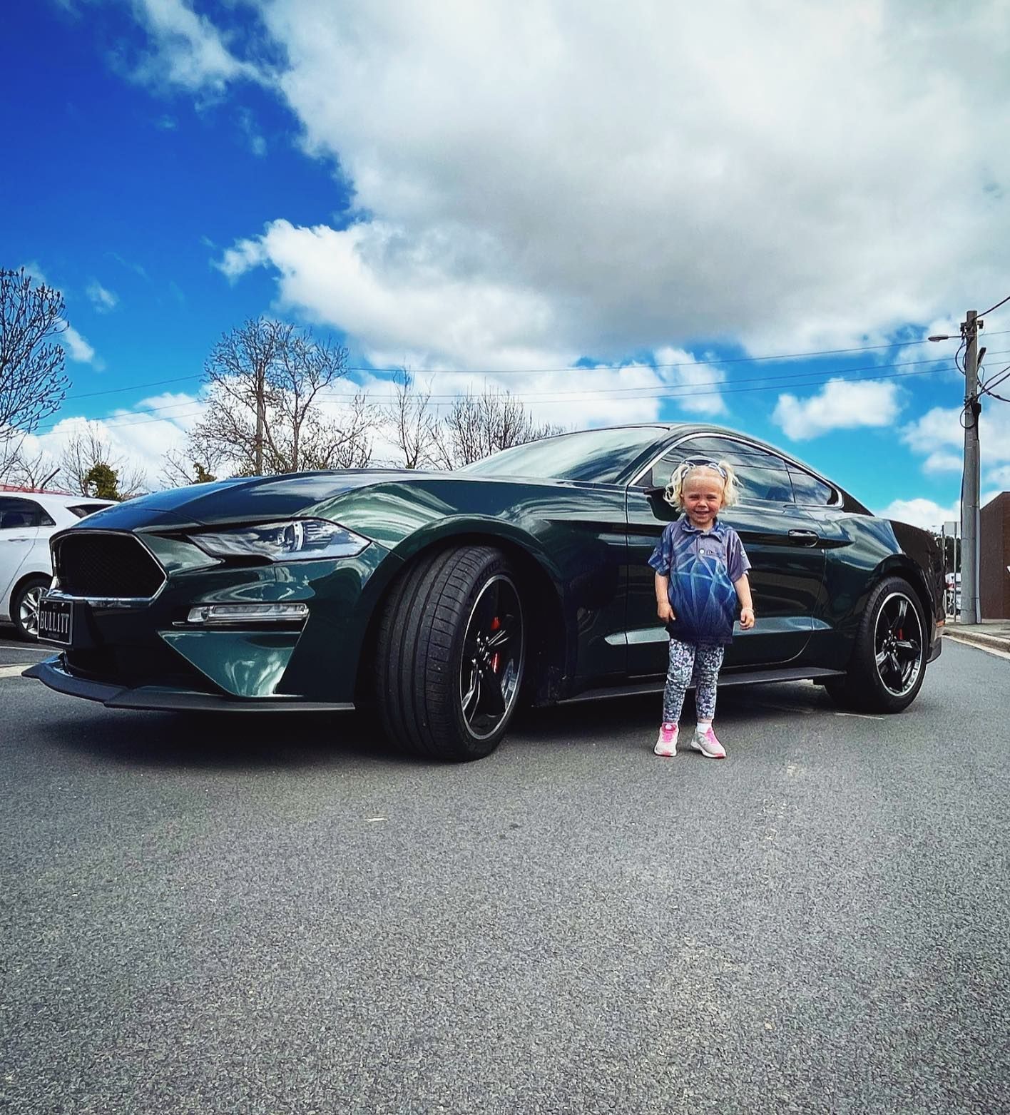 A Little Girl is Standing in Front of a Green Mustang — Diamond Tints In Phillip, ACT